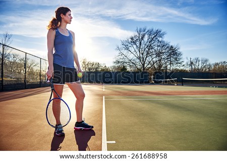 young woman standing on a tennis court