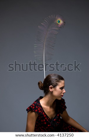 beautiful young woman wearing peacock feather in hair