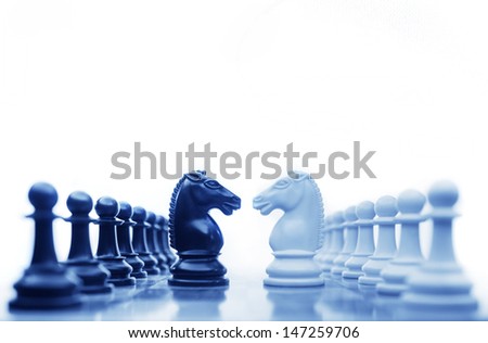 Chess horses facing each other for a standoff in cool tones