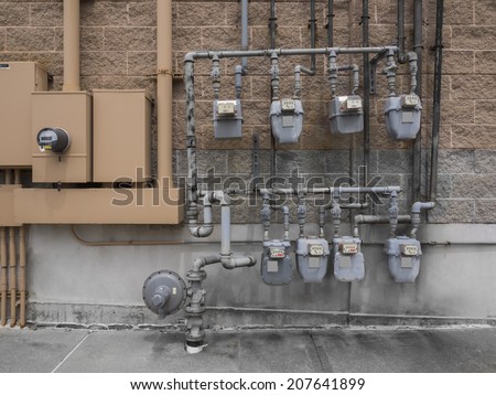 Bank of individual commercial natural gas meters on building exterior to measure  consumption