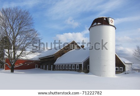 Barn with silo covered in snow during New England winter