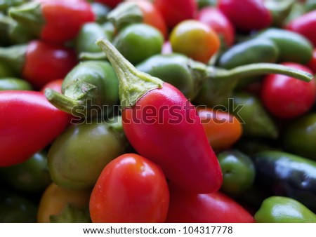 Close-up of assorted hot chili peppers with different size and color at street market.