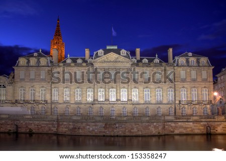 River facing facade of the Rohan Palace in Strasbourg, France at night.