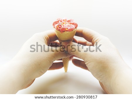 Woman hands holding a candy ice cream edited with soft colors and soft light.