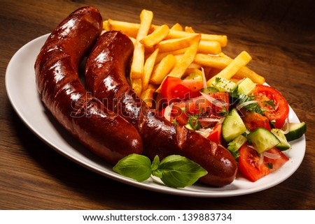 Grilled sausages with chips and vegetables