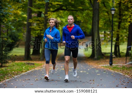 Young woman and man running in park