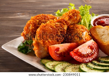 Fried chicken drumsticks and vegetables