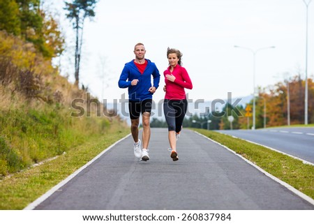 Healthy lifestyle - woman and man running in park