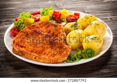Fried pork chops, boiled potatoes and vegetable salad