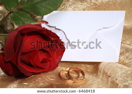 Red rose, blank card and wedding rings