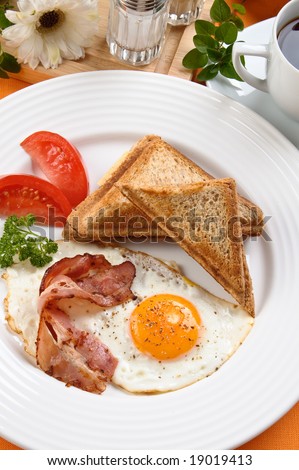 Breakfast - toasts, egg, bacon and vegetables