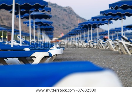 Large amount of empty lounges on the beach on Rhodes island in the evening