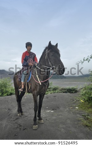 JAVA, - DECEMBER 18: An undefined kid and his horse at the Tengger National Park around Mount Bromo on Dec 18  2011 in Java  Indonesia. Indonesia sits on the \'ring of fire\' with many active volcanoes