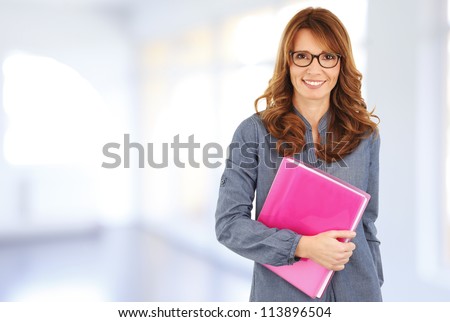 Business woman standing in the office, holding a file in her hands