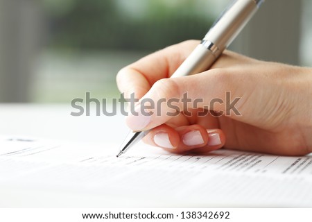 Businesswoman's hand with pen completing personal information on a form Imagine de stoc © 