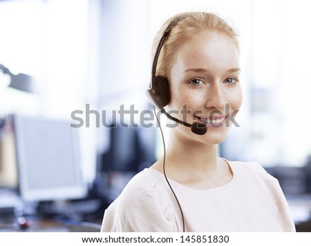 Beautiful Customer Representative with headset smiling during a telephone conversation