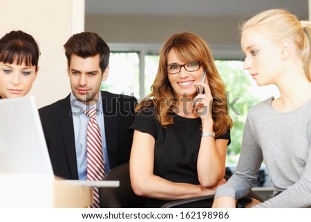 Teamwork. Happy businesswoman sitting at office with her colleagues