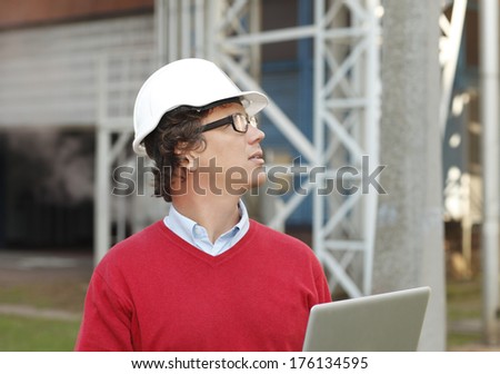 Construction architect working on laptop at construction site.