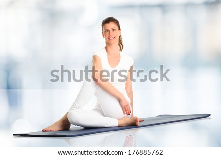 Besutiful woman doing yoga in studio.