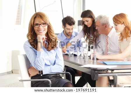 Beautiful executive businesswoman sitting at meeting.  Business group.