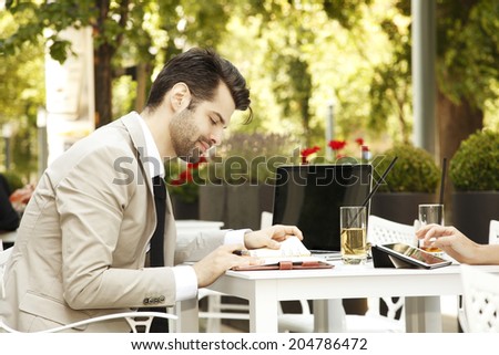 Young businessman sitting in coffee shop while making financial plan. Small business.