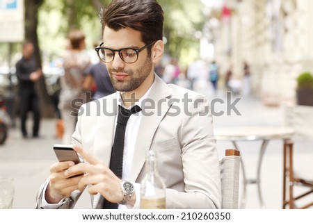 Modern businessman and business woman sitting at coffee shop and using mobile. Business people.