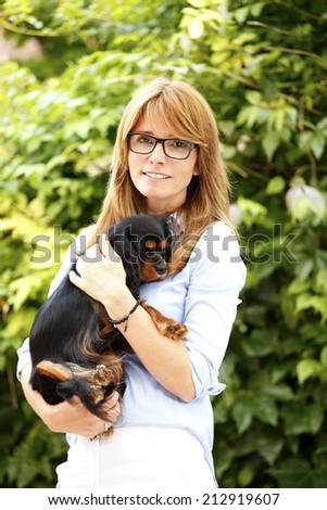 Female veterinarian carrying king charles cavalier puppy.