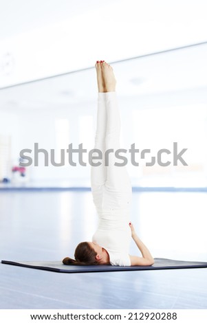 Yoga instructor doing exercise on yoga mat in studio.