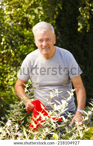 Portrait of retired casual man gardening at nursing home garden. Daily routine.