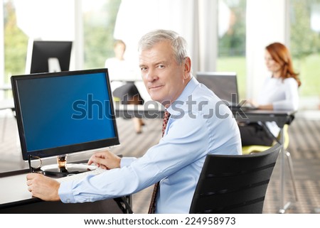 Close-up portrait of executive senior businessman sitting at office. Business people.