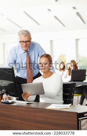 Sales woman holding tablet and discussing problems with senior businessman.
