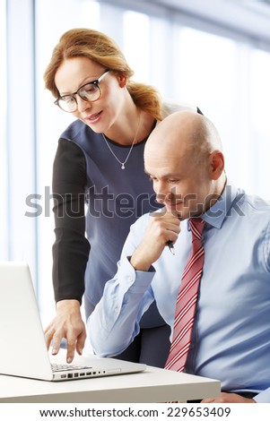 Sales woman and sales man working together on laptop while sitting at office. Business people.