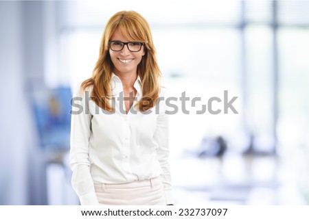 Portrait of executive sales woman standing at office.