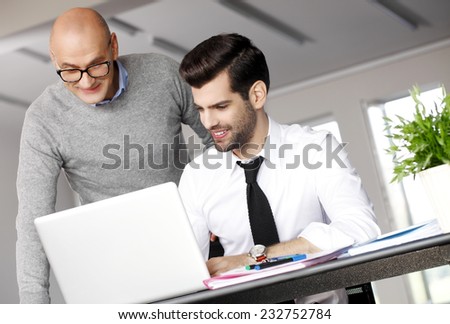 Portrait of young businessman giving advise to young sales man. Business team.