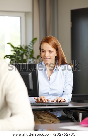 Portrait of executive sales woman working on laptop while sitting at meeting room.