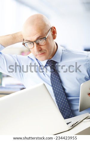Executive marketing businessman sitting at office while working on laptop.