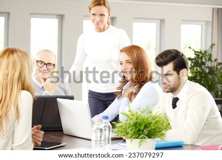 Executive business woman giving advise to sales team while sitting at meeting.