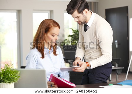 Young businessman holding digital tablet and presenting his idea to chief financial officer.