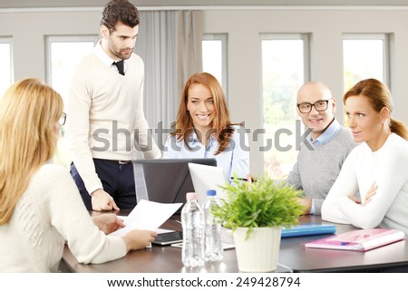Executive business woman presenting her idea to business team while they sitting at meeting.