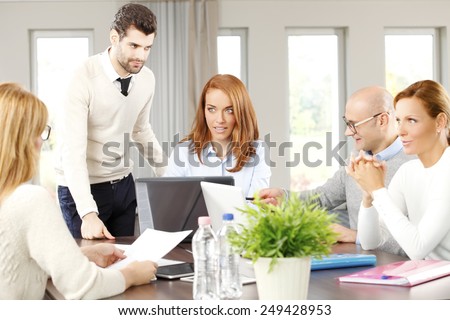 Executive business woman presenting her idea to business team while they sitting at meeting.