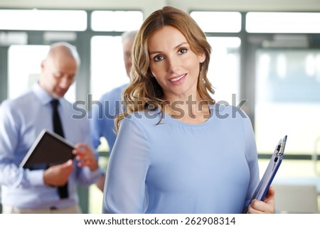 Portrait of female executive smiling while sitting at business meeting at office.