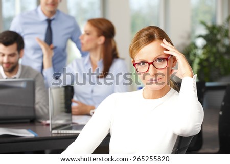 Portrait of executive business woman sitting at office while her financial team working at background with laptop. Teamwrok at office.