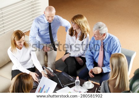 High angle view of business people sitting at meeting. Executive businesswoman presenting her idea to sales team while they are on staff meeting at office. Teamwork.