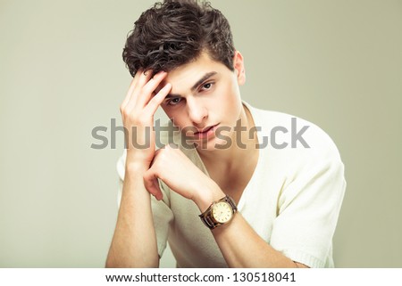stylish fashion man model sitting on the chair with watch on his hand