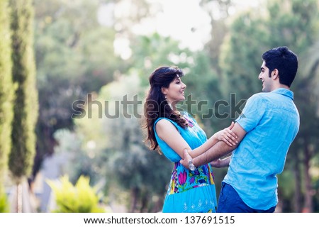young couple in love cuddling in the park, circling in the dance