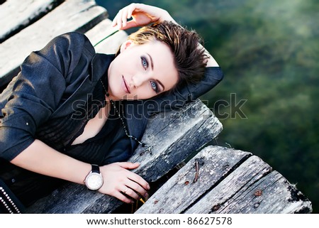 Young beautiful fashion model with hair and make-up professionally done outdoors