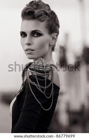 Young beautiful fashion model with hair and make-up professionally done outdoors.black and white
