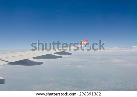 TOKYO, JAPAN - JULY 10: Thai AirAsia X (TAAX) plane\'s wing with logo on the window, the plane flying over Bangkok-Thailand to Tokyo Japan on July 10 2015. AirAsia as Asia\'s Leading Low Cost Airline.