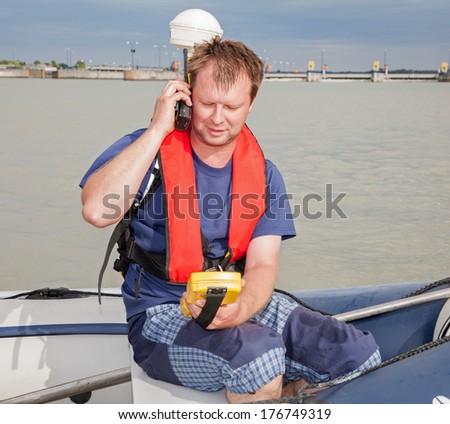 Man on the boat at  measuring with the GPS on the Danube river