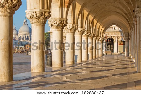 Venice - Exterior corridor of Doge palace and church Santa Maria della Salute in background.